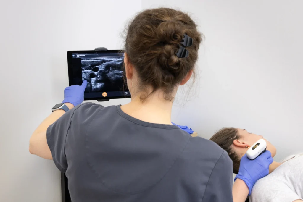 2025-07 Wells Medicine - Stellate Ganglion Block - EA3A0286 Physician pointing to ultrasound imaging used for a stellate ganglion block.